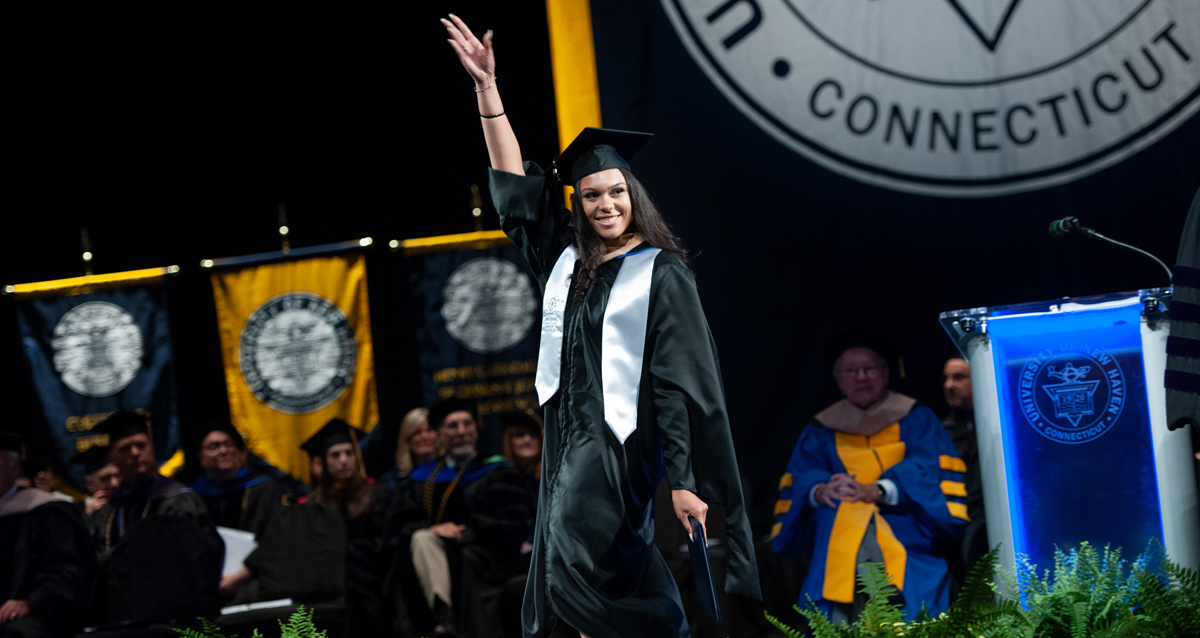 Photo of a student walking across the stage at the afternoon commencement ceremony on Wednesday, May 22, 2019.