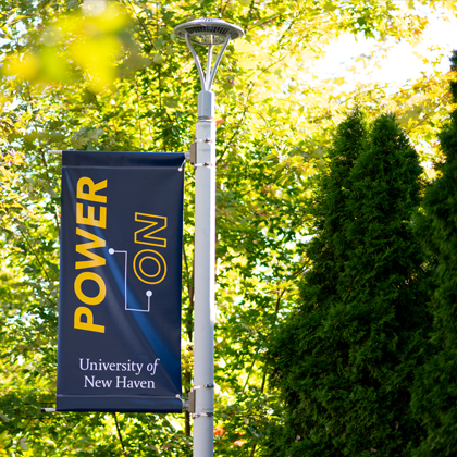 A Power On sign hangs on a lightpole on campus.