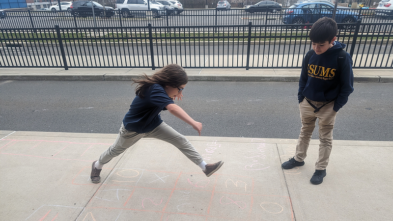 Students playing hopscotch.