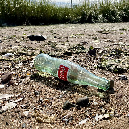 Empty bottle on sand
