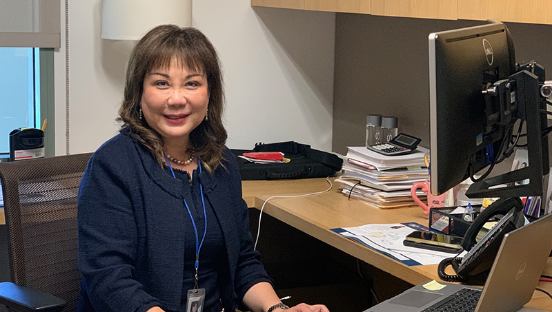 Alice Gao '94 MBA sitting behind her desk.