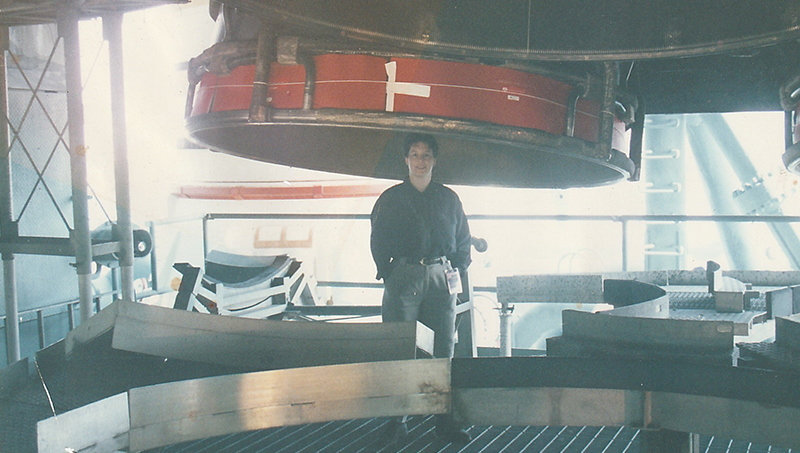 Ann Cox ’83 at the Kennedy Space Center launch pad under one of three Space Shuttle main engines.