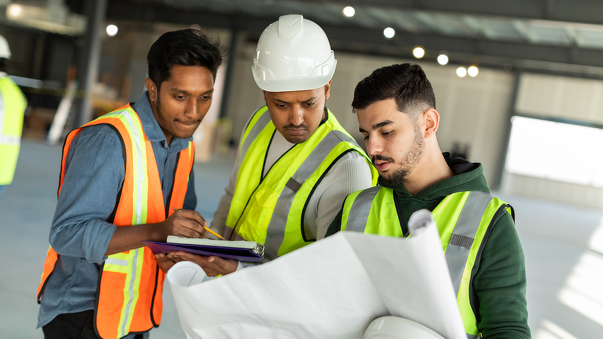 Men in hard hats studying plans