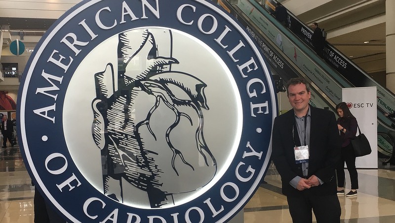 Image of Karl Minges with American College of Cardiology sign.