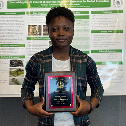 Timilehin Oluwole ’24, ’25 M.S. with her award and her poster.