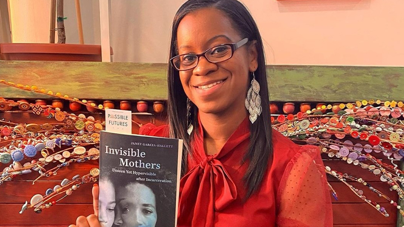 Janet Garcia-Hallett, Ph.D., with a copy of her book.