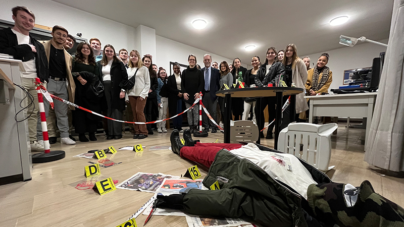 Prof. Daniel Maxwell (center) and students check out a mock crime scene at the police station.