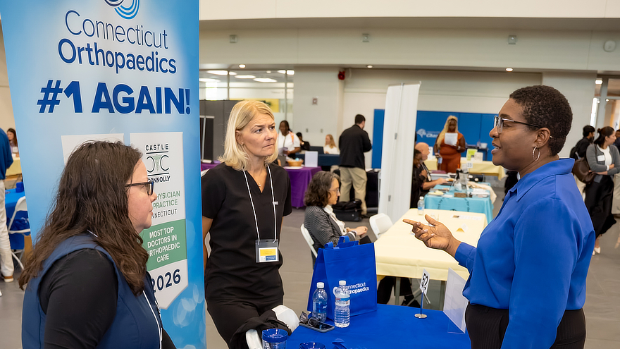 Student talks with company reps at career fair