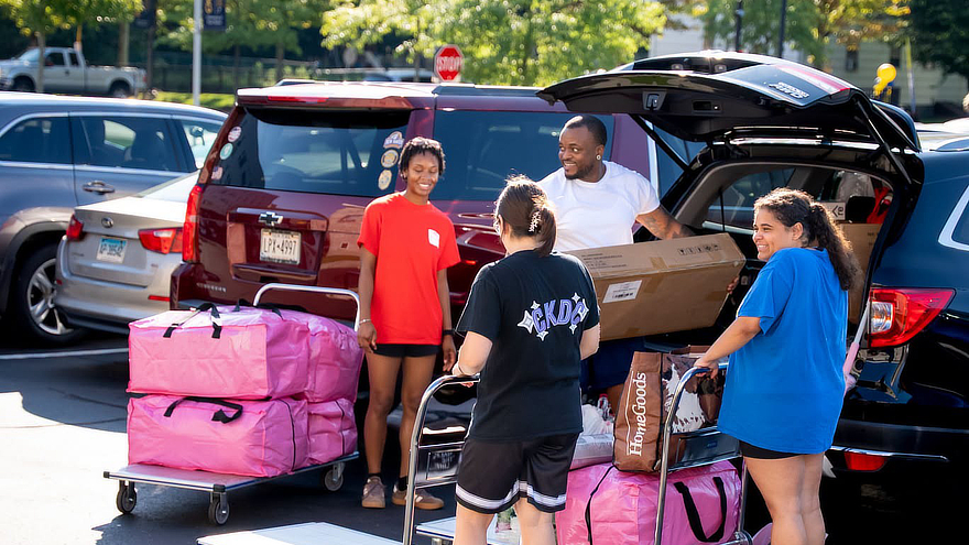 Families unloading bags from cars