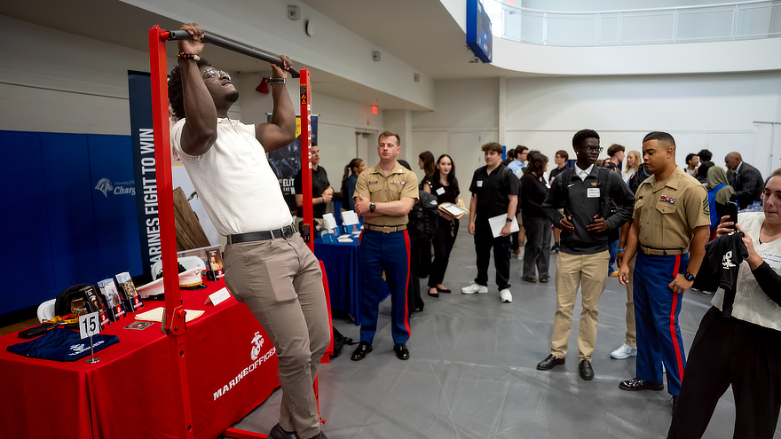 Student does pull-ups at a Marine recruitment table
