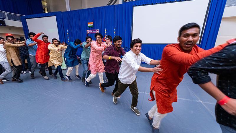 Students dancing and enjoying delicious Indian food.