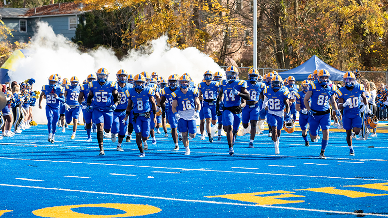 The University’s football team charges onto the field.