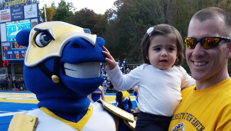 Image of Andrew Dinkel, daughet Madalyn, and Charlie the Charger at Homecoming in 2014.