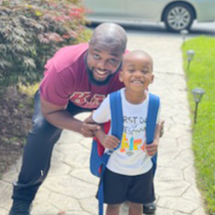 Jim Prosper posing with his son James Jr. on his first day of school.