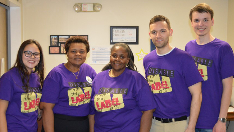 Linda Copney-Okeke, shoulder-to-shoulder, posing for a photo in matching purple 'disable the label' shirts.