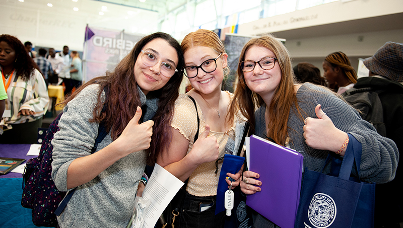 Students posing for a photo with a thumbs up.