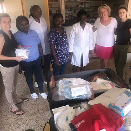 Image of Laney Phillips and her mother (right) bringing medical supplies to doctors and nurses in Uganda.