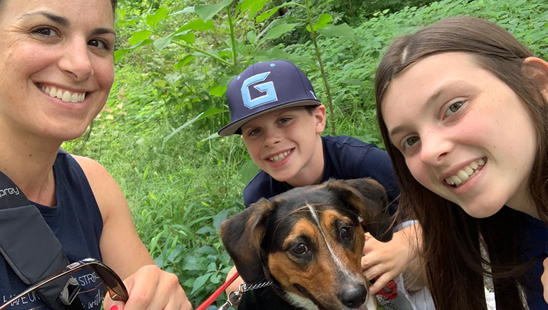 Image of Jessica Scibek, her twins, and dog Cookie out for a walk in the woods.
