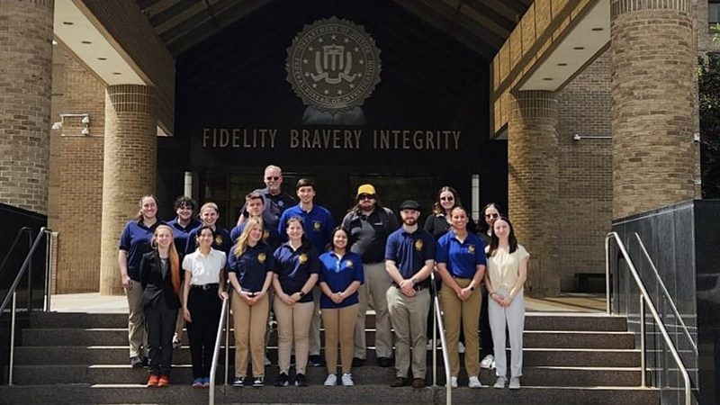 The American Criminal Justice Association and Graduate Forensic Science Club at the entrance to the FBI Academy.