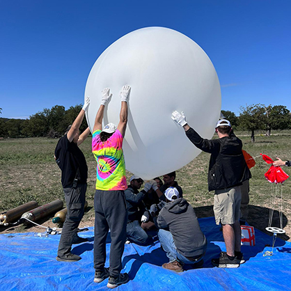 Faculty and students get the balloon ready to go. 