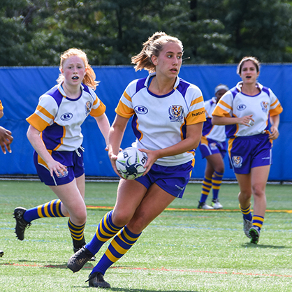 The women's rugby team playing on the field