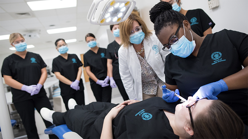 Prof. Marie Paulis (center) and dental hygiene students at the University.