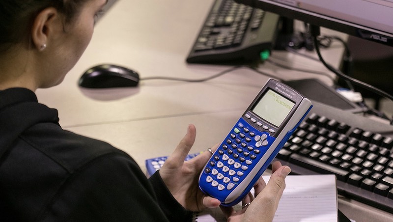 Image of a student using their calculator.