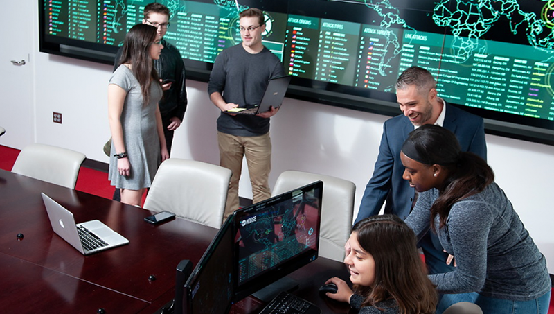 Students in the national security program gathered around computers and chatting.